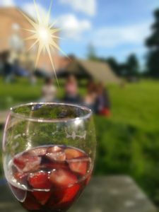 Glass of pimms with a glinting window and blue sky in the background